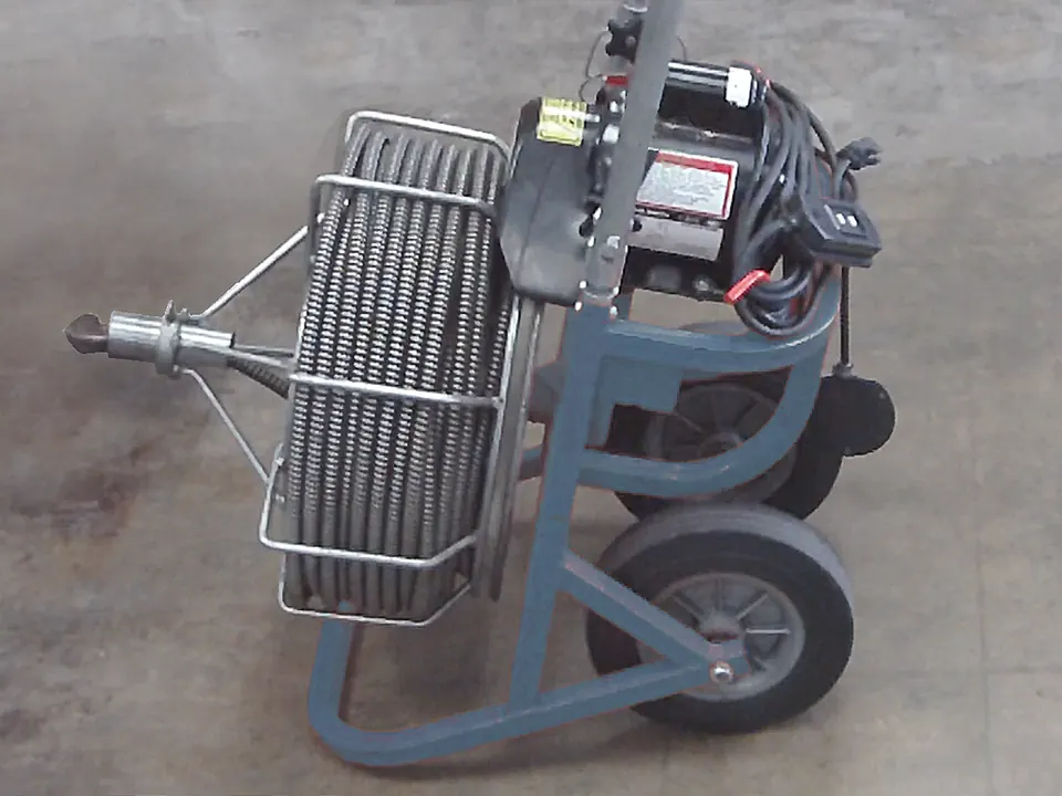 Electric drain-cleaning machine with a coiled cable and wheeled frame