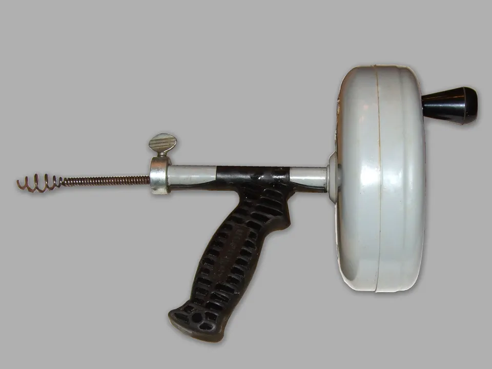 Handheld drain auger with a flexible cable for fixture drain clearing